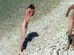 Nudist redhead swimming in the water