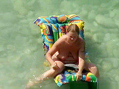 Chubby nudist woman with tattooed arm