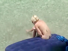 Group of nudists relaxing in the beach