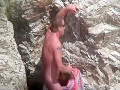 He led her to the rocks for a blowjob