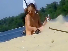 Cute topless girl smoking on a beach