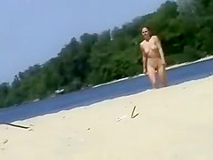 Cute topless girl smoking on a beach