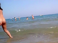 Naked girl plays in the shallow water