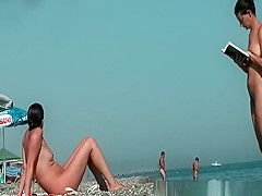 Nudist woman reading book in the beach