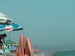 Nudist woman reading book in the beach