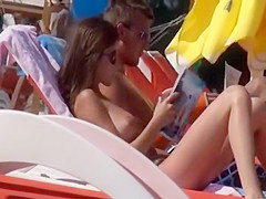 Topless girl reading and sunbathing