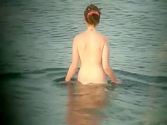 Nude hippie woman getting out of water
