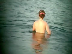 Nude hippie woman getting out of water