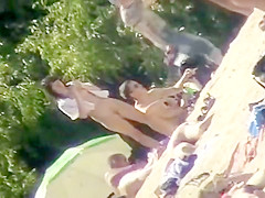 Young nudists take off their clothes to soak up some sun on