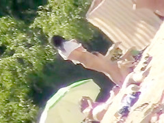 Young nudists take off their clothes to soak up some sun on