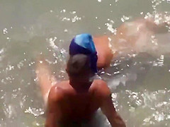 Girl sucks dick her boyfriend in the surf at a public beach