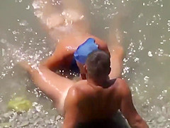 Girl sucks dick her boyfriend in the surf at a public beach