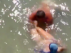 Girl sucks dick her boyfriend in the surf at a public beach