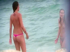 Topless friends on beach, one with giant boobs