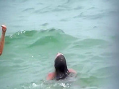 Topless friends on beach, one with giant boobs