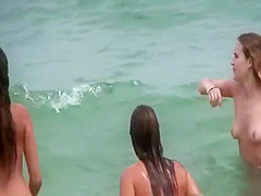 Topless friends on beach, one with giant boobs