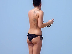 Classless chick with big tits and tattoo's on a beach