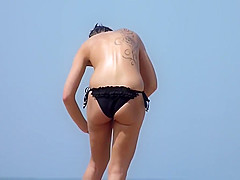 Classless chick with big tits and tattoo's on a beach