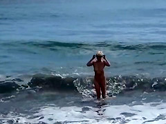 Cute blonde gets off on public beach