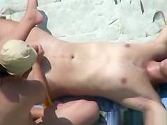 Voyeur 7925-Handjob at nudist rocky beach
