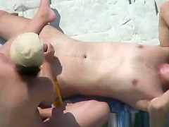 Voyeur 7925-Handjob at nudist rocky beach
