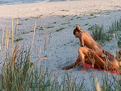 Amateur couple got caught having sex on the beach by voyeur.