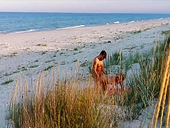 Amateur couple got caught having sex on the beach by voyeur.