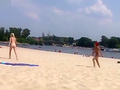 TWO TEENS AT A NUDIST BEACH PLAYING BEACH BALL