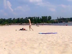 TWO TEENS AT A NUDIST BEACH PLAYING BEACH BALL