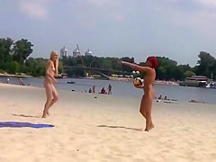 TWO TEENS AT A NUDIST BEACH PLAYING BEACH BALL