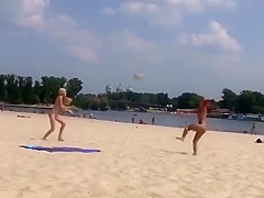TWO TEENS AT A NUDIST BEACH PLAYING BEACH BALL