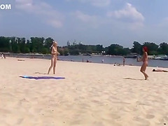 TWO TEENS AT A NUDIST BEACH PLAYING BEACH BALL