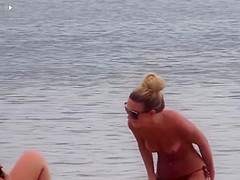 Slim babe with sexy body filmed with her tits out on the beach