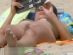 Hot body babe lying down on the beach surprised by a spy cam