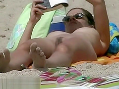 Hot body babe lying down on the beach surprised by a spy cam