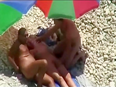 Threesome sex fun on public beach caught on voyeur cam