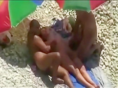 Threesome sex fun on public beach caught on voyeur cam