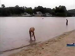 Nude girls outdoor on public beach having fun