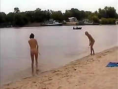 Nude girls outdoor on public beach having fun