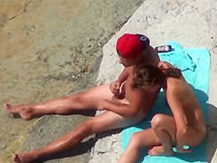Couple of mutually masturbating to orgasm at a public beach