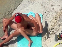 Couple of mutually masturbating to orgasm at a public beach