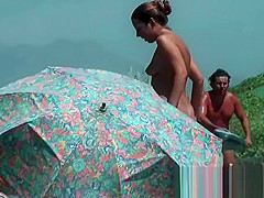 Nude beach voyeur spies on a perky breasted nudist