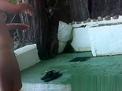 Spy cam shot of a hot nudist babe tanning on the beach