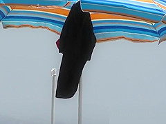 Real beach nudist is stretching on the sand