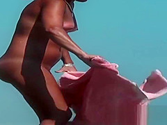 Sexy toned body walking naked on a crowded beach