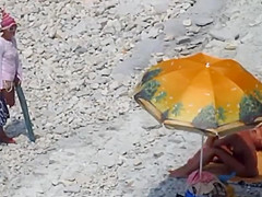 Couple strips and blows on the beach