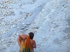 Couple strips and blows on the beach