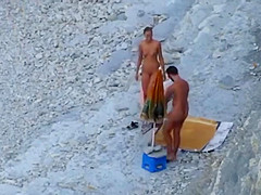 Couple strips and blows on the beach