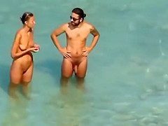 Couple strips and blows on the beach