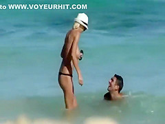 Skinny topless girl enters the water